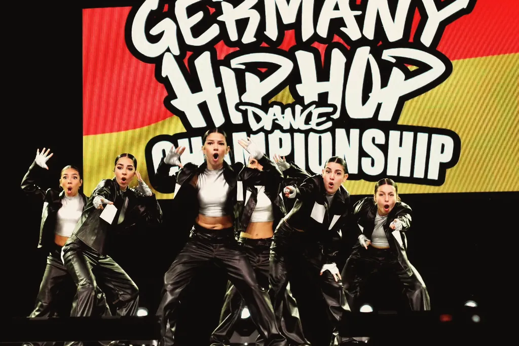 Crew in black leather outfits in front of the Germany Hip Hop Dance Championship 2024 banner