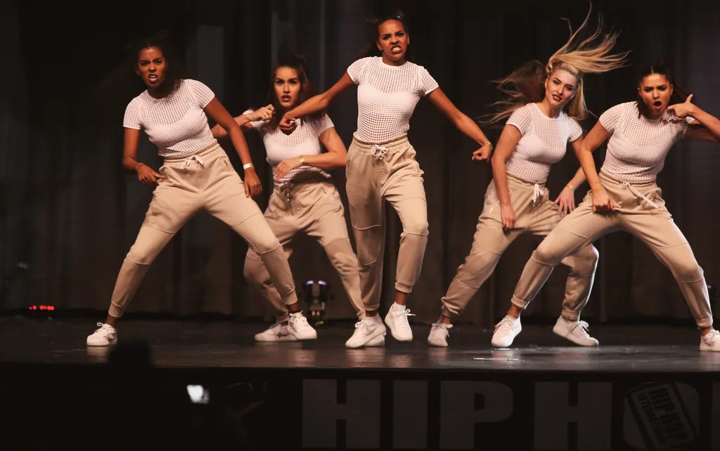 All-female crew in beige with flying hair on the HHI stage