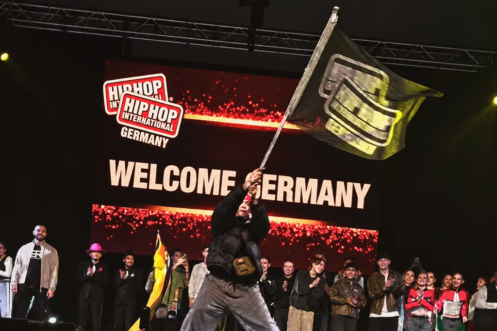 “Welcome Germany” at the Worlds: a dancer waves the flag in front of the teams of all nations